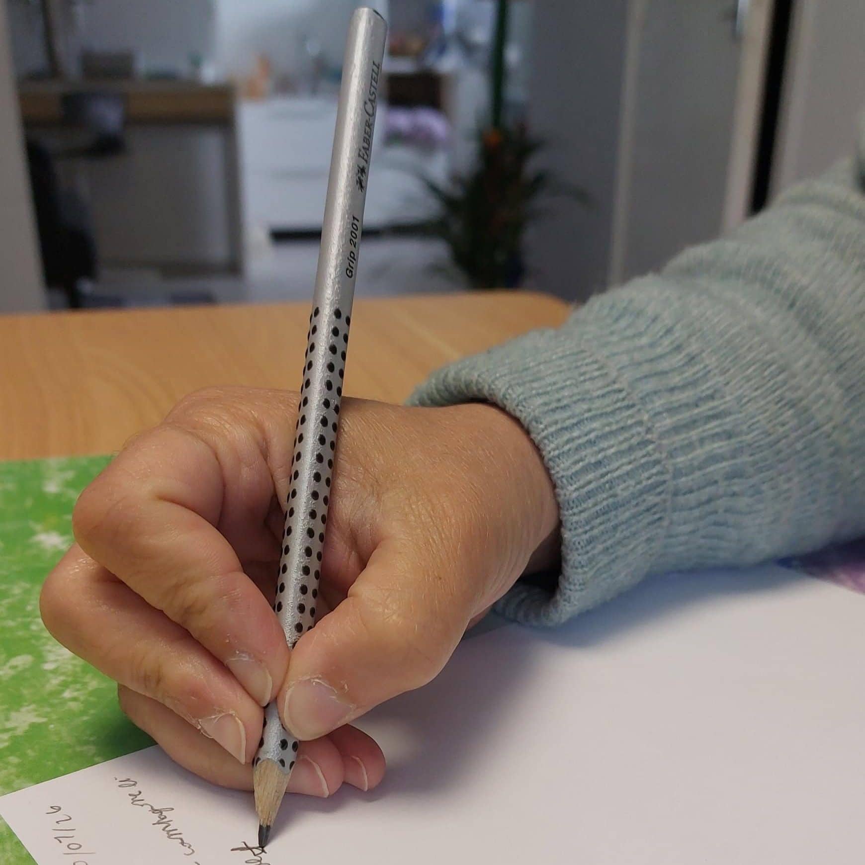 préhension du crayon quadripode chez l'enfant, le crayon reposant sur l'annulaire avec quatre doigts.